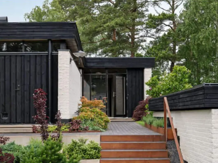Modern black and white villa with garden and entrance
